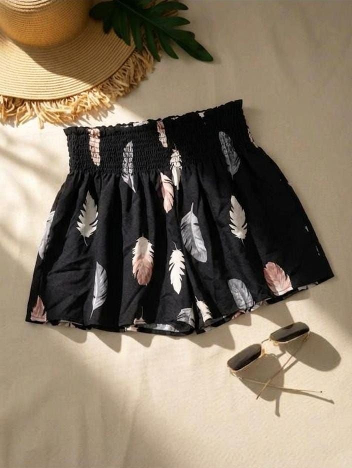 Short casual de color negro con estampado de plumas en tonos neutros y pastel, una cintura alta elástica tipo nido de abeja